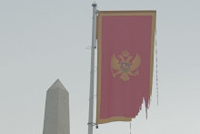 <p>Поцијепана застава крај споменика</p>